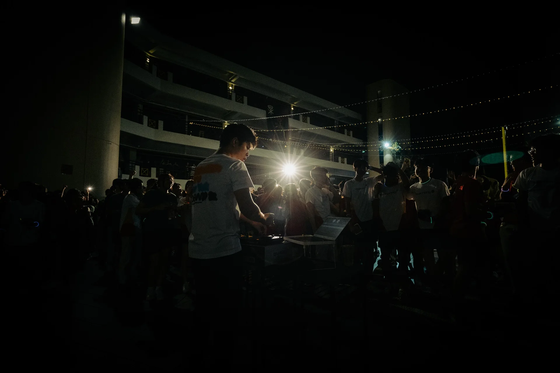 A performer and audience framed by a bright stage light