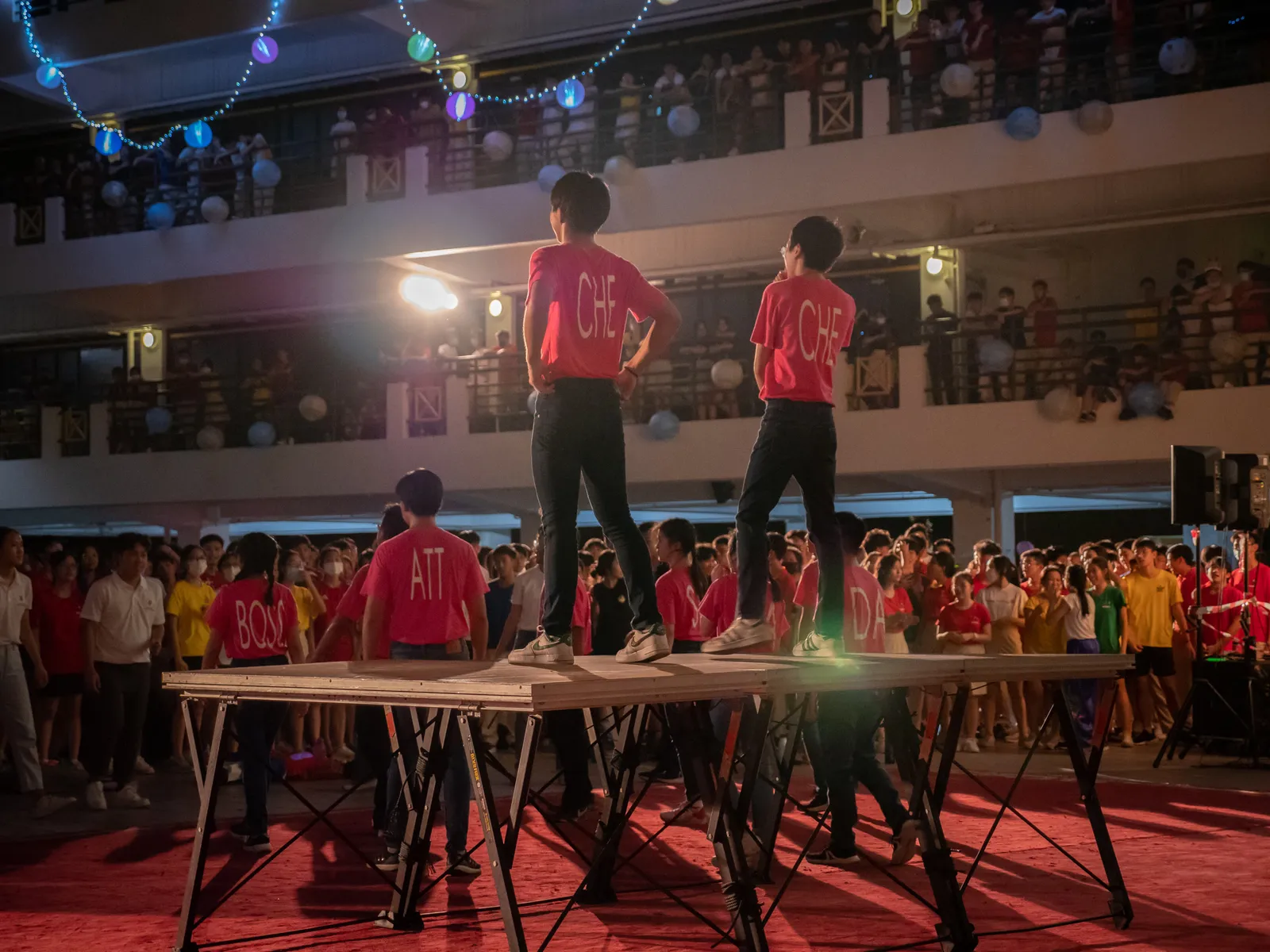 Student performers standing above a crowd at a night event